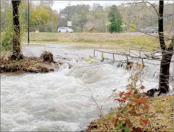  ?? Keith Bryant/The Weekly Vista ?? Floodwater rushes over a golf cart bridge and fills a section of the Country Club golf course.