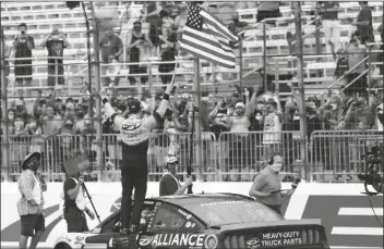  ?? ASSOCIATED PRESS ?? DRIVER BRAD
KESELOWSKI celebrates with the American flag after winning a NASCAR Cup Series race Sunday at the New Hampshire Motor Speedway in Loudon, N.H. The 2012 Cup champion took the checkered flag at New Hampshire Motor Speedway on Sunday, beating Denny Hamlin by 1.647 seconds after trading the lead with him for most of the 301-lap race. “it’s so great to be racing back in front of fans again. It feels like forever, so welcom back, guys,” said Keselowski.