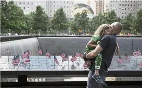  ?? — AFP ?? Honouring the dead: A man looking at the US flags placed on the 9/11 Memorial in the Manhattan borough of New York City.