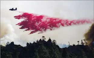  ?? ANDA CHU STAFF ARCHIVES ?? A Cal Fire air tanker drops fire retardant on the Glass fire east of Mount Saint Helena in Calistoga on Oct. 3. Officials reported Monday that the fire, which broke out Sept. 27, is at more than 90% containmen­t.