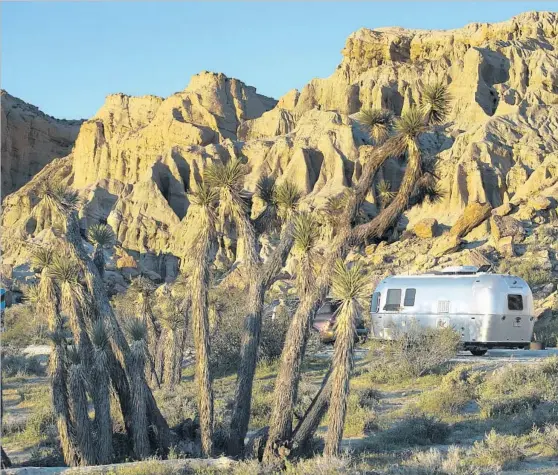  ??  ?? THE GLEAM of a 22-foot Airstream Sport stands out in the stark Mojave Desert setting of California’s Red Rock Canyon State Park. The trailer contains a luxurious bed, a dining room table, a stove, a refrigerat­or and a full-size shower.