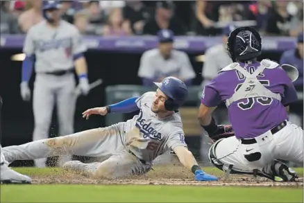  ?? David Zalubowski Associated Press ?? TREA TURNER produces one of his famous stylistic slides to make it safely home and score the second of five runs for the team in the fourth inning. Turner was three for four at the plate with three RBIs before being removed from the blowout of the Rockies.