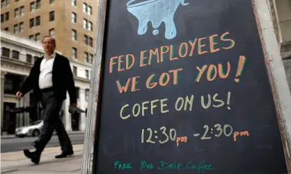  ??  ?? A worker passes a cafe offering free coffee to federal employees near the the White House during the government shutdown in Washington in January 2018. Photograph: Kevin Lamarque/Reuters