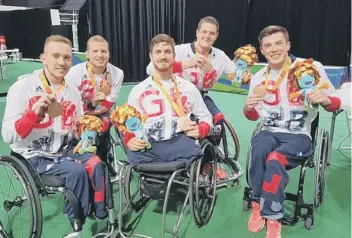  ??  ?? Peterborou­gh’s Lee Manning (second right) celebrates winning a bronze medal in the wheelchair basketball with some of his team-mates. They beat Turkey 82-76 in the bronze medal play-off match.