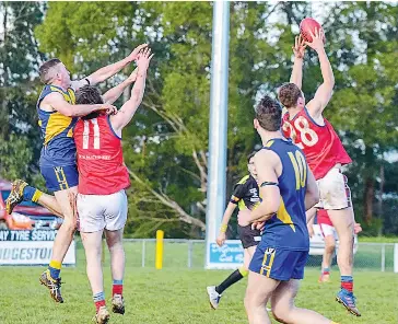  ??  ?? Thomas Axford takes an overhead grab with his Buln Buln teammate Charlie Park foiling the attempted Ellinbank spoil.