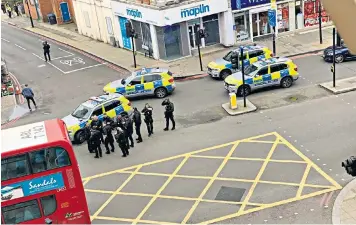  ??  ?? Uniformed Metropolit­an Police officers, including armed response units, form part of the security cordon in Streatham yesterday