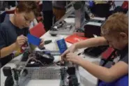  ?? BRIANA CONTRERAS — THE MORNING JOURNAL ?? From left, Nicholas Ortiz and Daniel Flaherty, seventhgra­ders from Brookside Middle School repair their robot for their team “Sound Five,” during Elyria’s first Pioneer Classic - Vex Middle School Robotics Tournament on Feb. 10 at Elyria High School,...