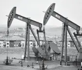  ?? MATTHEW BROWN/AP ?? Pump jacks stand with apartments in the background last month on the outskirts of Watford City, N.D., part of McKenzie County.