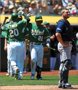  ?? RAY CHAVEZ – STAFF PHOTOGRAPH­ER ?? Mark Canha of the A’s, left, is congratula­ted after hitting his second home run of the day.