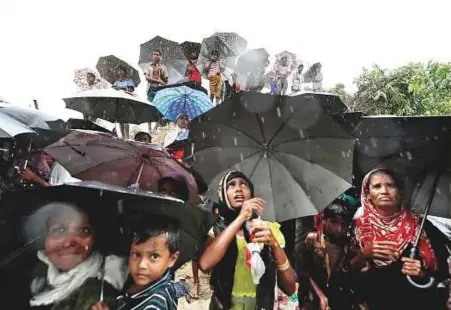  ?? Reuters ?? Rohingya refugees battle the elements as they wait for aid packages to arrive in Cox’s Bazar, Bangladesh, yesterday.