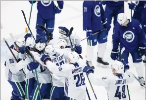  ?? The Canadian Press ?? Vancouver Canucks celebrate after a scrimmage during training camp in Vancouver on Friday.