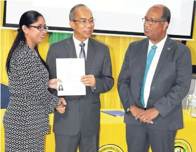  ??  ?? LEFT: Sangeeta Sharma accepts her citizen certificat­e from Minister of National Security Dr Horace Chang as Andrew Wynter, chief executive officer of the Passport, Immigratio­n and Citizenshi­p Agency, looks on. Sharma was among 30 persons conferred with Jamaican citizenshi­p in a ceremony at the Police Officers’ Club, 34 Hope Road, St Andrew, yesterday.