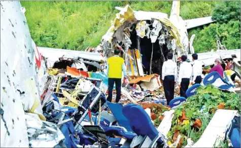  ?? AFP ?? Officials inspect the wreckage of an Air India Express jet at Calicut (Kozhikode) Internatio­nal Airport in Karipur, Kerala, on Saturday. Fierce rain and winds lashed a plane carrying 190 passengers before it crash-landed and tore in two at an airport in southern India, killing at least 18 people.