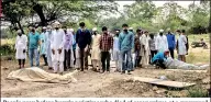  ??  ?? People pray before burying victims who died of coronaviru­s, at a graveyard in New Delhi