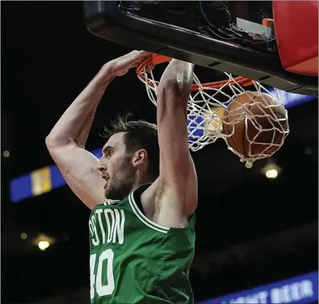  ?? JOHN BAZEMORE — THE ASSOCIATED PRESS ?? Celtics center Luke Kornet scores with a behind-the-head dunk during the second half of a win over the Hawks in Atlanta. Kornet was 7-for-7 from the floor.