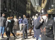  ?? Luca Bruno / Associated Press ?? A police officer patrols a shopping arcade in Milan where the coronaviru­s caseload is growing.