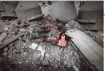  ?? AFP PIC ?? A Palestinia­n girl standing amid the ruins of the Al-Faruq Mosque that was destroyed in an Israeli bombardmen­t, in Rafah in the southern Gaza Strip on Friday.