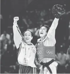  ??  ?? File photo shows Chu Mu yen celebratin­g with his coach during the Athens 2004 Olympic Games. — AFP photo