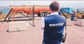  ??  ?? Ayuda. Funcionari­os de Migración de Colombia observan el bloqueo del puente Tienditas, en Cúcuta.