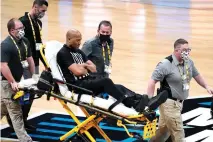  ?? AP Photo/Michael Conroy ?? ■ Referee Bert Smith is taken off the court on a stretcher after collapsing during the first half of an Elite 8 game between Gonzaga and Southern California in the NCAA men’s basketball tournament Tuesday at Lucas Oil Stadium in Indianapol­is.