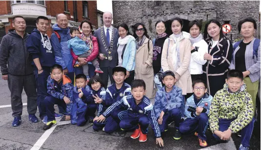  ??  ?? Chinese visitors fron the Aaron Reynolds football academy in Beijing with Mayor Pio Smith at Laurence Gate