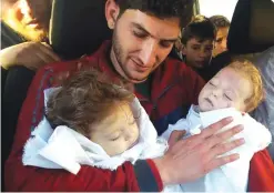  ?? — AP ?? IDLIB: Abdul-Hamid Alyousef, 29, holds his twin babies who were killed during a suspected chemical weapons attack, in Khan Sheikhoun in the northern province of Idlib, Syria.