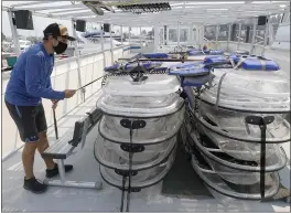  ?? JANE TYSKA — BAY AREA NEWS GROUP ?? Clearly Tahoe employee Ludovic Fekete checks on transparen­t kayaks aboard the company’s new boat, the “Clearly Tahoe,” at the Tahoe Keys Marina in South Lake Tahoe on Monday.