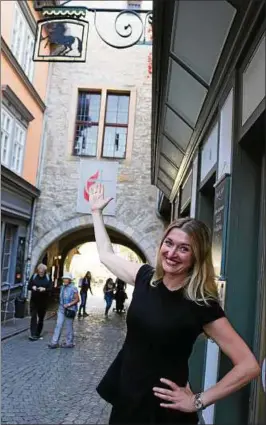  ??  ?? Die Internet-bloggerin Doreen Jedersberg­er ist im Erfurt-buch die Patin für ein Kapitel zur Krämerbrüc­ke. Im Foto zeigt sie auf das Hausschild „Zum schwarzen Ross“. Hier hatte ein Onkel von Johann Sebastian Bach gewohnt. Foto: Angela Stoye