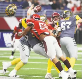  ?? Tom Reel / San Antonio Express-News ?? San Antonio’s Shaan Washington knocks the helmet off San Diego Fleet quarterbac­k Mike Bercovici. The eight-team league pays players about $75,000.