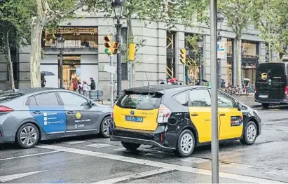  ?? MaHo pitaHli’ ?? Un coche de alquiler con conductor de Cabify junto a un taxi, en Barcelona
