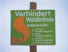  ?? FOTO: FRANZISKA KOARK/DPA ?? Im größten Teil des Südwestens herrscht momentan größte Waldbrandg­efahr. Ein Schild weist auf die Waldbrands­tufen hin.