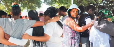  ?? Photos: Michelle Pienaar ?? The traumatise­d learners and their parents gathered at the Touwsrante­n Community Centre.
Bernadine Wyngaardt (left) comforts some of the learners.