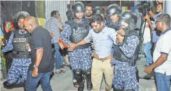  ?? AHMED SHURAU/ AFP/ GETTY IMAGES ?? Maldivian police detain an opposition protester demanding the release of political prisoners Tuesday in Malé, the capital.