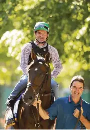  ?? Al Bello / Getty Images ?? Jockey Kent Desormeaux and trainer Keith Desormeaux lead Exaggerato­r onto the track before a training session for the Belmont.