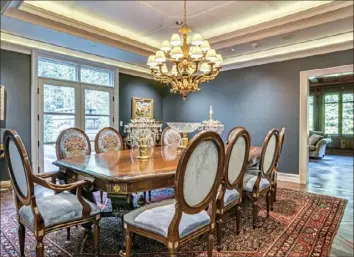  ??  ?? The dining room has a tray ceiling and French doors leading to a patio.