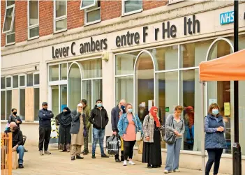  ?? AFP ?? Members of the public queue outside a Covid-19 vaccinatio­n clinic in Bolton, northwest England, on Friday. British Prime Minister Boris Johnson said Wednesday that Covid-19 vaccines are proving effective against a variant that has spread like wildfire in India and denied the government was being lax on travel from hotspots. —