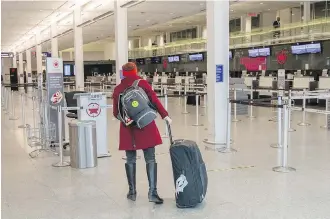  ??  ?? A passenger makes her way to check in at a nearly empty Trudeau Airport in Montreal.