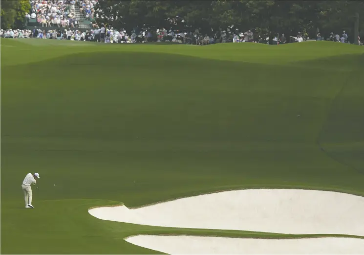  ?? CHARLIE RIEDEL / THE ASSOCIATED PRESS ?? Danny Willett of England hits from the fairway on the eighth hole during the second round of last year’s Masters golf tournament at Augusta National Golf Club. The hill is so
steep the green can’t be seen from the fairway. While the green has no bunkers, it does features several large mounds.