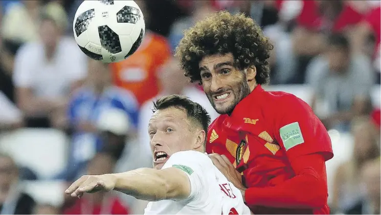  ?? CZAREK SOKOLOWSKI/THE ASSOCIATED PRESS ?? England’s Ashley Young battles with Marouane Fellaini of Belgium on Thursday in Kaliningra­d, Russia. Belgium won the group stage match 1-0.