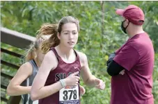  ?? Bud Sullins/Special to the Herald-Leader ?? Shayla Conley crosses the bridge during a stretch of the Panther Cross Country Classic.