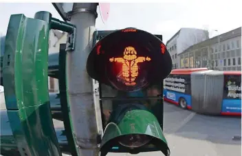  ?? FOTO: HARALD TITTEL/DPA ?? Kein gewöhnlich­es Ampelmännc­hen: An einer Ampel in der Trierer Innenstadt zeigt Karl Marx den Fußgängern an, ob sie gehen dürfen oder warten müssen.