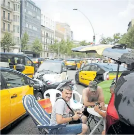  ?? AFP ?? Protestas. Grupo de conductore­s con sus taxis bloqueando la calle.