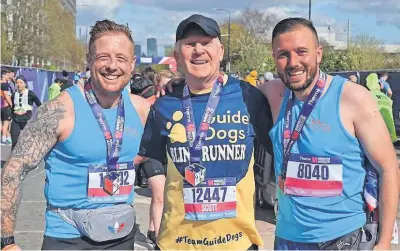  ?? ?? Job done Scott at the finish in Manchester with guide runner Sgt Tom Merryman of the Royal Marines and Jake Ellis