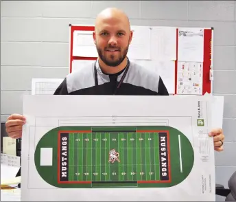  ?? RACHEL DICKERSON/MCDONALD COUNTY PRESS ?? McDonald County High School athletic director Bo Bergen holds a mock-up of the new turf field that will be installed. Along with a new athletic sports complex, the field is part of improvemen­ts to the school’s athletics program.