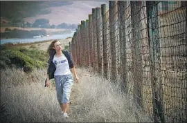  ??  ?? ANIMAL activist Fleur Dawes is seeking the removal of an 8-foot-high wire fence that runs across the Point Reyes peninsula, preventing the free movement of elk.