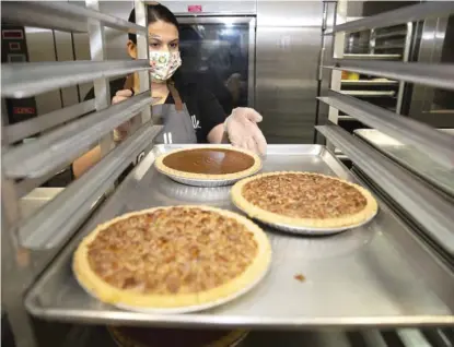  ?? ANTHONY VAZQUEZ/ SUN- TIMES ?? Vanille Patisserie owner Sophie Evanoff racks pies to be given away next week in Englewood.