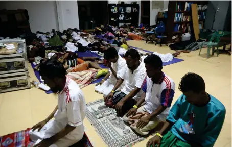  ?? PERSECUTED COMMUNITY
AP ?? Rohingya refugees hold a morning prayer in a temporary shelter at the Indonesian Red Cross Office, after being evacuated from the sea at Meulaboh, West Aceh, Indonesia.