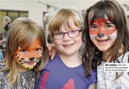  ??  ?? All smiles This trio got their faces painted at the church festival