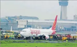  ??  ?? SpiceJet's Boeing 737 Aircraft, with 183 people on board, skidded off the rainsoaked runway while landing at Chhatrapat­i Shivaji Internatio­nal Airport; (below) Municipal workers try to retrieve the lid of a manhole to prevent pedestrian­s from falling...