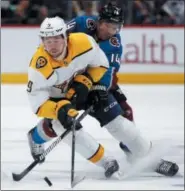  ??  ?? Nashville Predators left wing Filip Forsberg, front, picks up the puck as Colorado Avalanche left wing Blake Comeau defends in the third period of Sunday’s game in Denver.